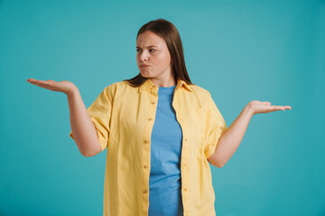 Young white woman wearing shirt frowning while holding copyspace