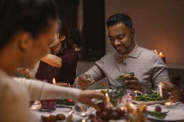 holidays, party and celebration concept - group of happy friends having christmas dinner at home