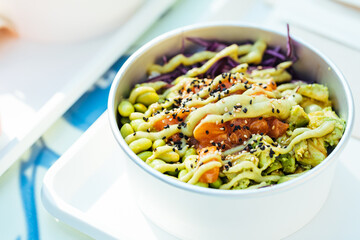 Poke bowl with salmon or tuna, avocado, beans and lot of different ingredients ready for take out