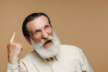 Fototapeta premium European senior man with beard screaming and pointing finger upward