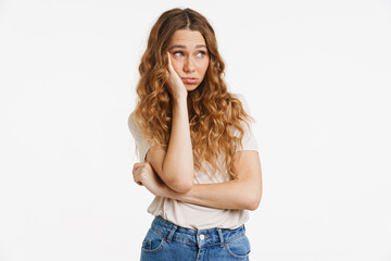 Young ginger woman in t-shirt frowning while propping up her head