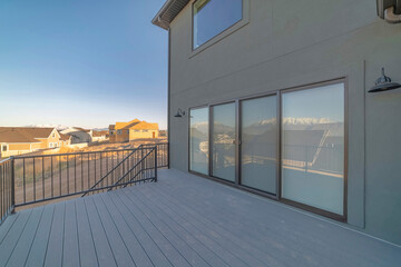 Deck of a house with sliding glass door and wooden planks flooring