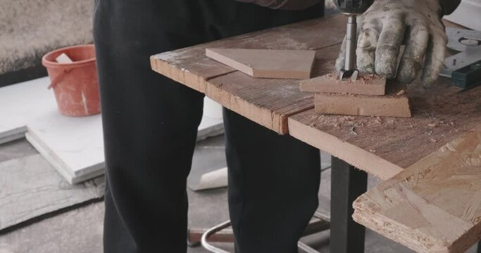 Close-up of router wood fixed with clamps on a wooden surface with which a hobbyist drills a circular hole in a piece of wood
