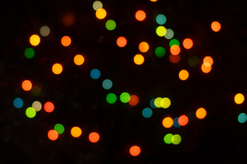 Defocused abstract yellow, green, orange and blue light circles. Bokeh is distributed throughout the frame