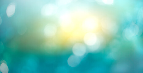 A winter abstract sky background with cold wintery blue and sunshine yellow bokeh sparkling sun in...