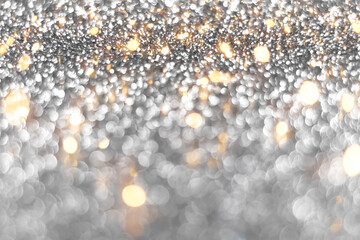 Silver and golden sparkling glitter bokeh background, christmas abstract defocused texture. Holiday lights