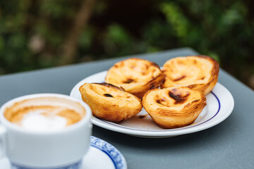 Egg custard tarts called Pasteis de Nata with two coffees 