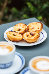 Egg custard tarts called Pasteis de Nata with two coffees 