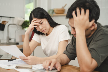 Stressed, hand of asian young couple love family, confused by calculate expense from invoice or bill, have no money to pay. Mortgage, loan causing debt, bankruptcy. Debt problems, Financial people.
