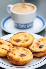 Egg custard tarts called Pasteis de Nata with two coffees 