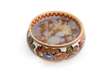 Pork jelly in the clay bowl on a white background