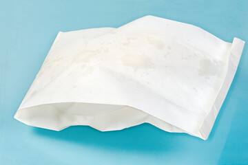 Street food packed in paper food bag on blue surface
