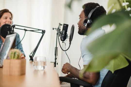 Happy multiracial coworkers recording podcast