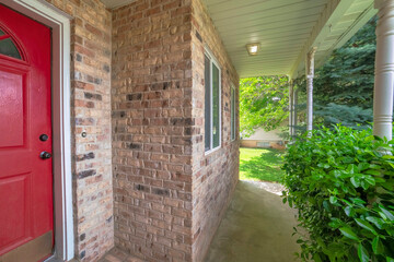 Porch of a house with bricks and plants at the front