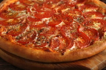 round whole pizza margarita with tomatoes, cheese and spices on a wooden dark background
