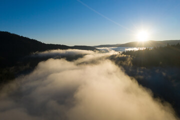 Aerial view of mountain sunrise above clouds