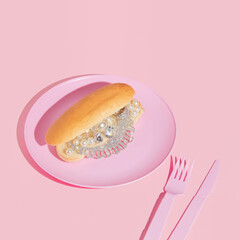 Creative layout with luxury jewelry in hot dog bun on pink plate on pastel pink background.  80s or...