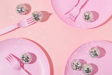 Christmas and New Year creative layout with plates, forks, knifes and disco ball decorations on...