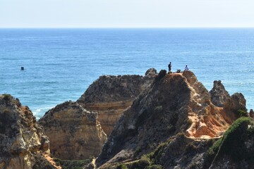 Fototapeta na wymiar Two unidentified tourists in Ponta de Piedade, the Algarve, Portugal