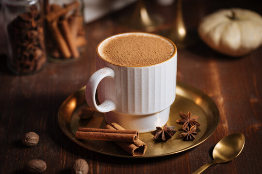 A cup of pumpkin spice latte or salep in a rustic wooden autumn atmosphere
