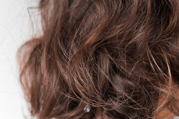 Close up of curly hair of a brunette woman. Brown laid curls of a young girl back view, beauty...