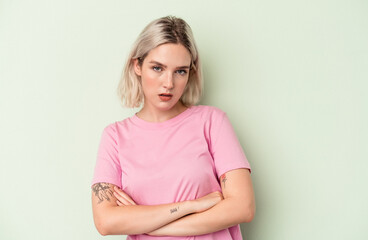 Fototapeta premium Young caucasian woman isolated on green background who is bored, fatigued and need a relax day.