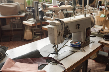 Close-up of workplace with sewing machine for seamstress on it in the factory