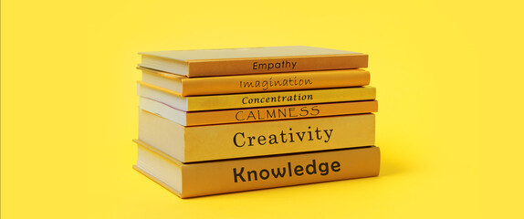 Stack of books with titles book reading benefits on spines. Yellow books banner.