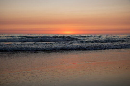 Rötlicher Sonnenuntergang am Meer mit Wellen in El Palmar Andalusien Spanien © Stefan