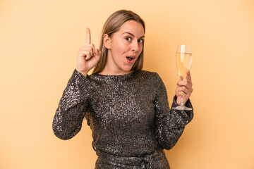 Young caucasian woman celebrating new year isolated on yellow background having an idea, inspiration concept.