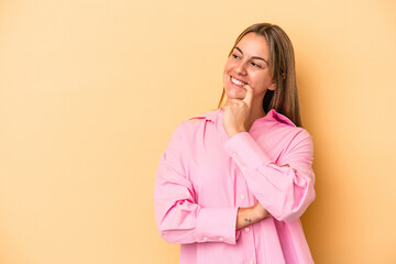 Young caucasian woman isolated on yellow background relaxed thinking about something looking at a copy space.