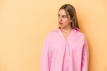 Obraz premium Young caucasian woman isolated on yellow background being shocked because of something she has seen.