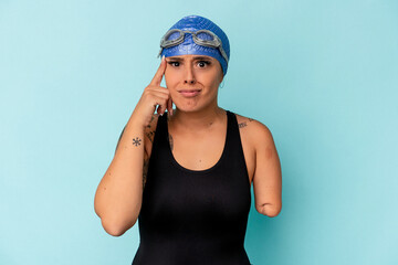 Young swimmer caucasian woman with one arm isolated on blue background showing a disappointment gesture with forefinger.