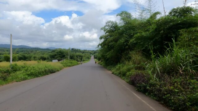 Driving bush jungle road Firestone Liberia rubber plantation. West Africa a nation suffers with extreme poverty and hunger. Congested crowded homes, markets, streets and businesses. Tropical climate.