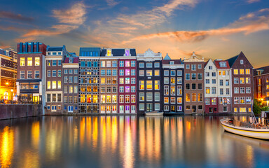Old houses of Amsterdam in the evening. The houses stand in the water and have a beautiful...