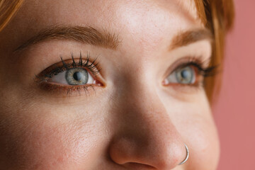 Fototapeta premium Cropped face of young beautiful girl without makeup isolated over pink studio background. Natural beauty concept.