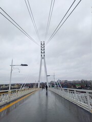 Obraz premium Suspended cable-stayed bridge in cloudy autumn weather after rain