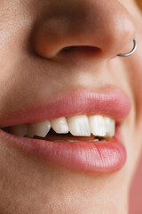 Close-up female mouth and nose isolated over pink studio background. Natural beauty concept. Dental health concept