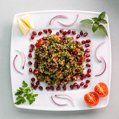 Traditional Tabbouleh salad with parsley on white table. Table top view.