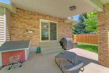 Backyard lounge area with pet house and covered barbecue griller