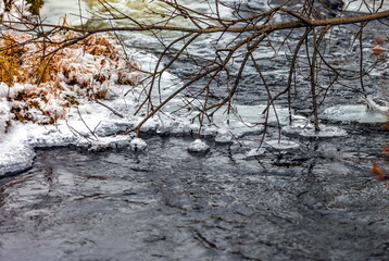 Fast river with ice in late autumn