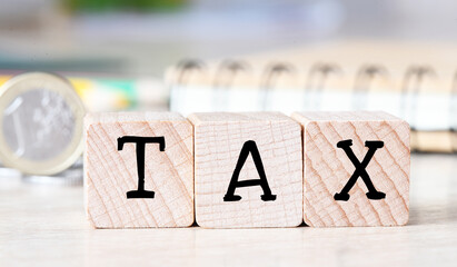 TAX text on wooden cubes on the wooden background. Tax Business Concept .