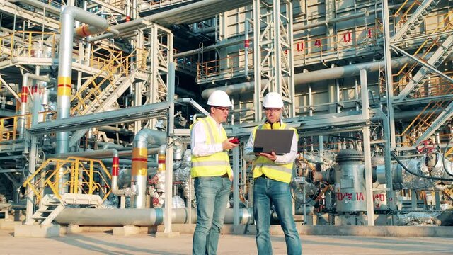 Oilfield engineers are talking at the oil-processing factory
