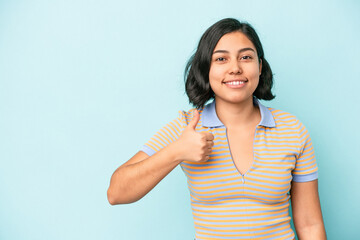 Fototapeta premium Young latin woman isolated on blue background smiling and raising thumb up