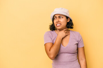 Naklejka premium Young latin woman isolated on yellow background touching back of head, thinking and making a choice.
