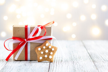 Gingerbread star and box of gift on bokeh lights background