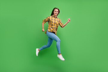 Fototapeta na wymiar Full body profile portrait of overjoyed pretty lady running beaming smile look camera isolated on green color background