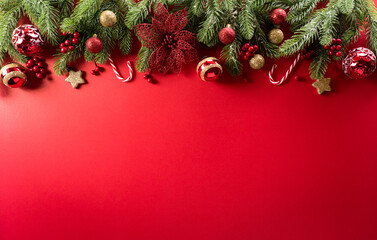 Christmas and new year background concept. Top view of Christmas decoration made from snowflake, christmas ball and  pine branches on red background.