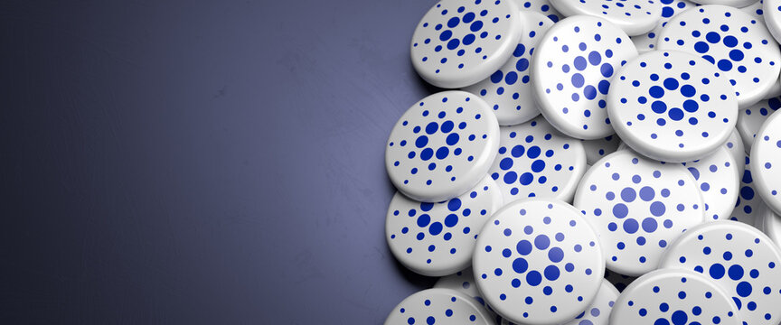 Logos of the cryptocurrency Cardano (ADA) on a heap on a table. Copy space. Web banner format