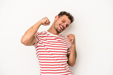 Young caucasian man isolated on white background celebrating a special day, jumps and raise arms...